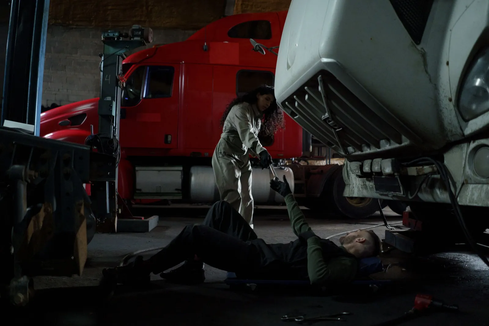 Two technicians working under a truck