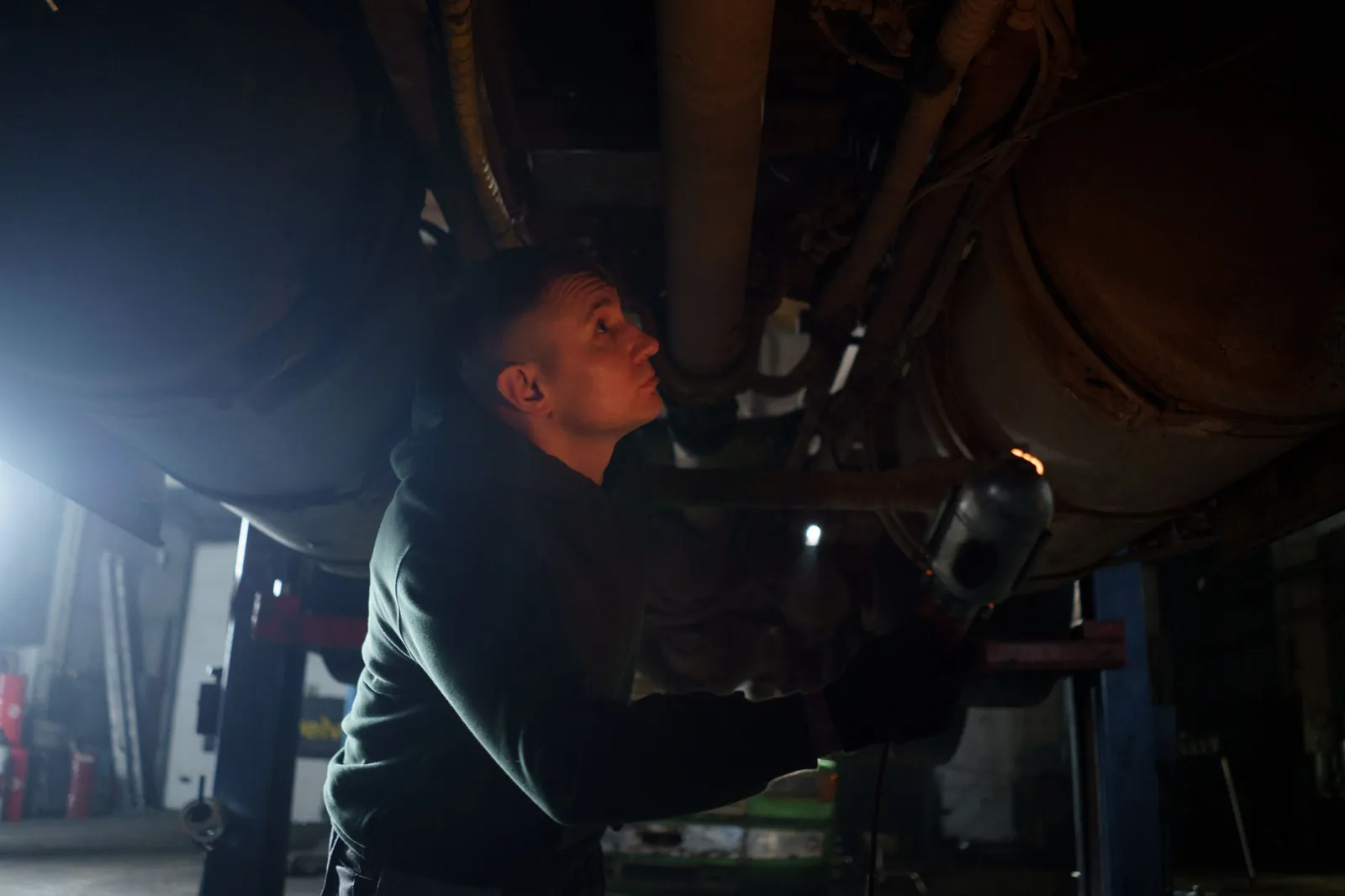 A technician checking the underside of a truck with a light