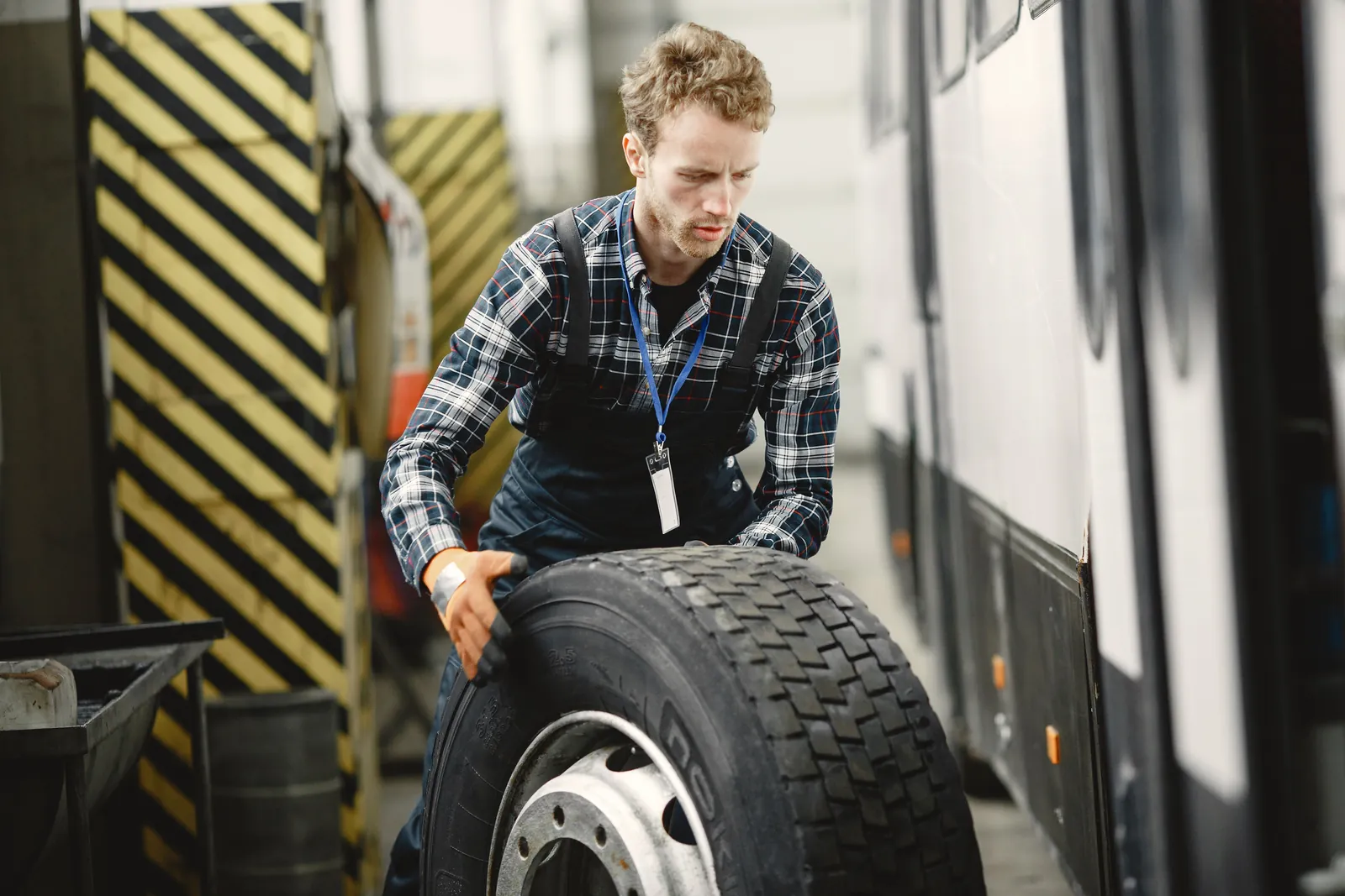 A technician rolling a heavy truck wheel