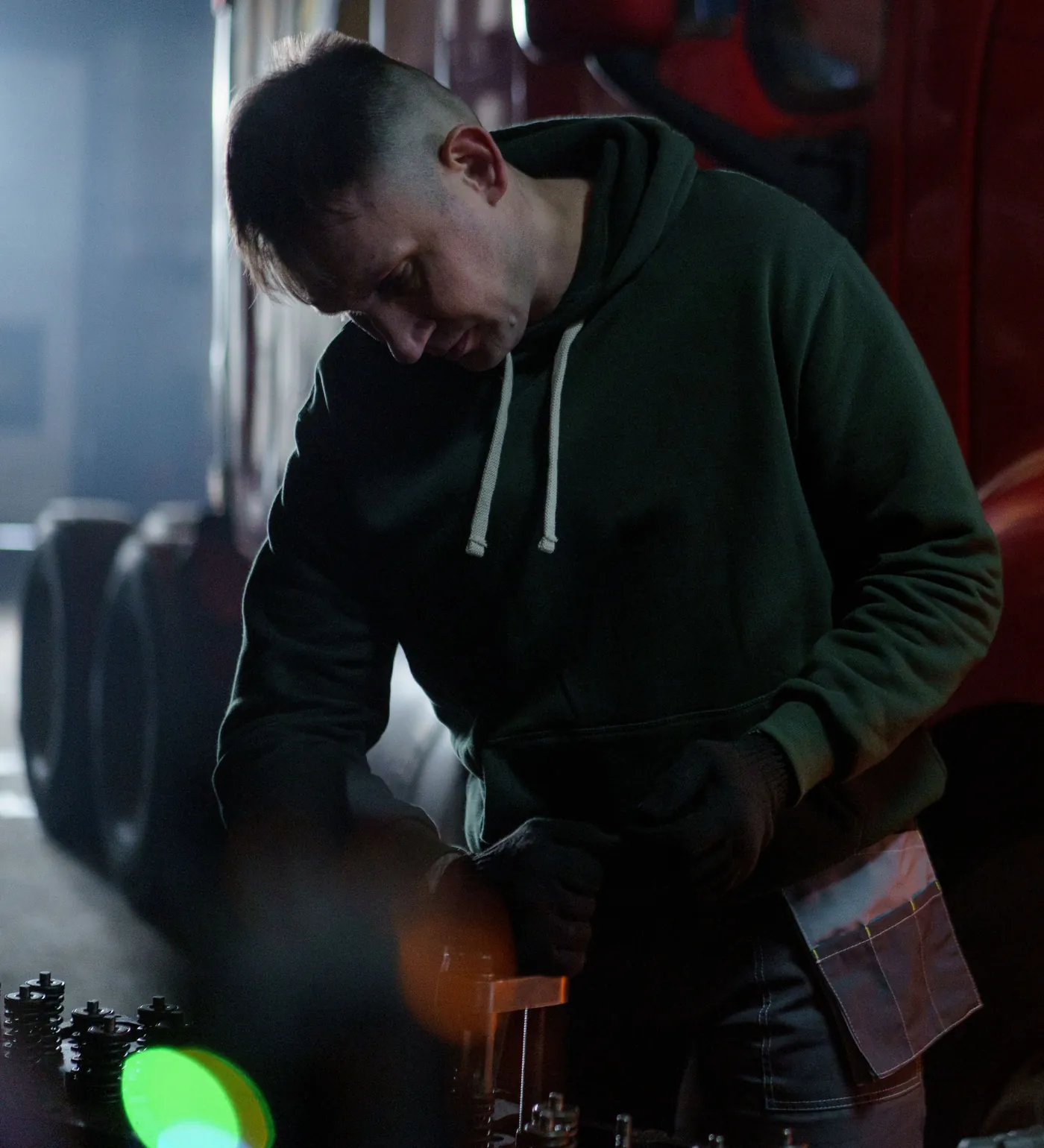 A technician at the bench beside a red tractor
