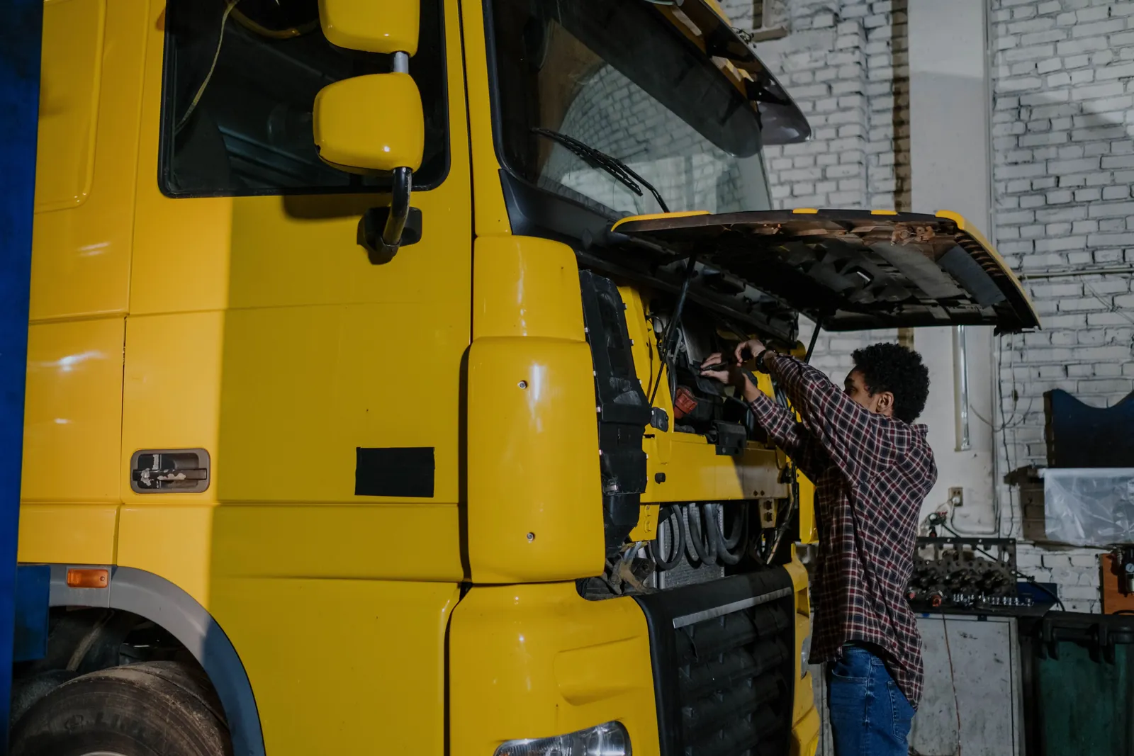 A technician working in the open front of a truck cab