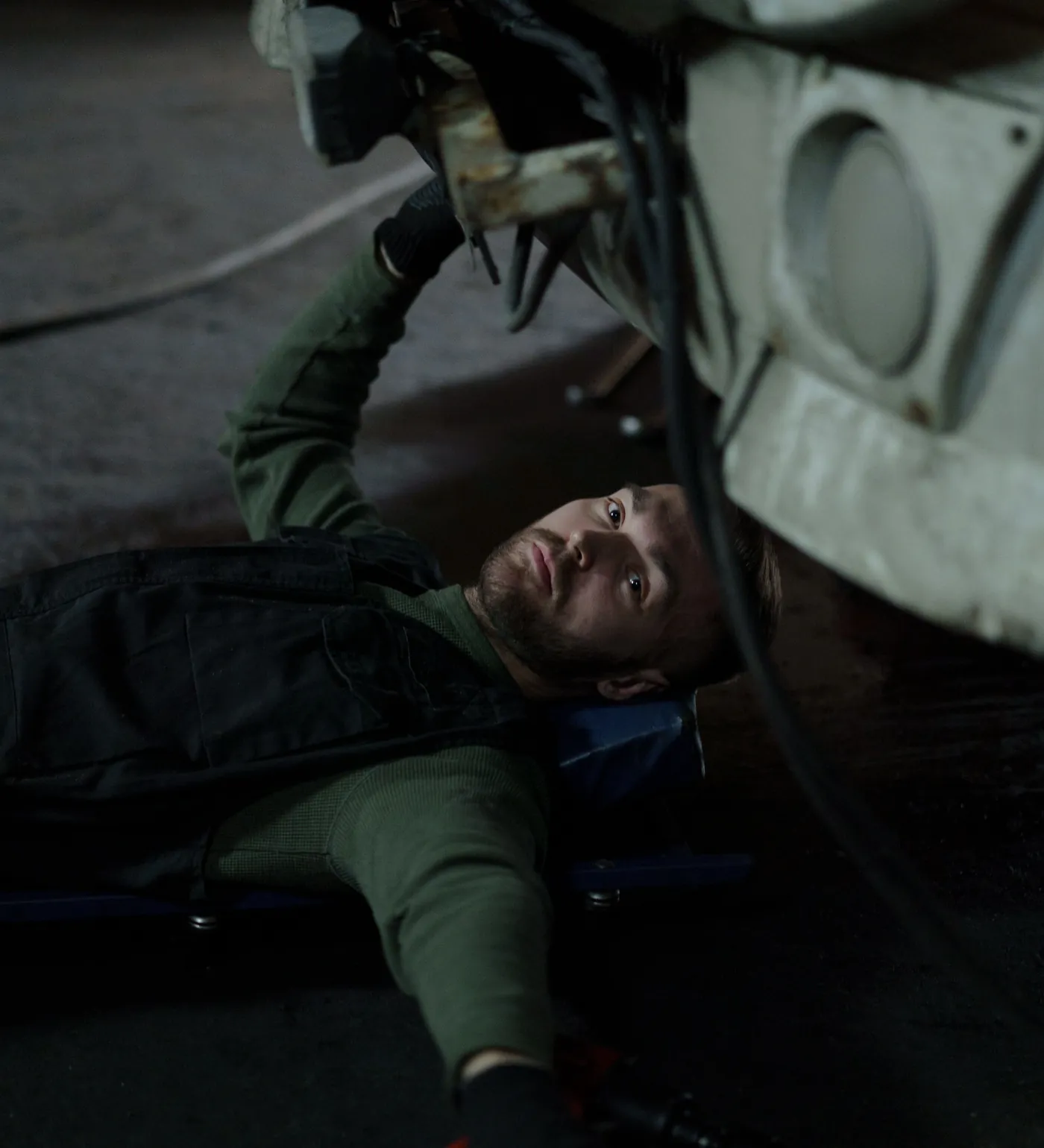 A technician on a creeper under a truck
