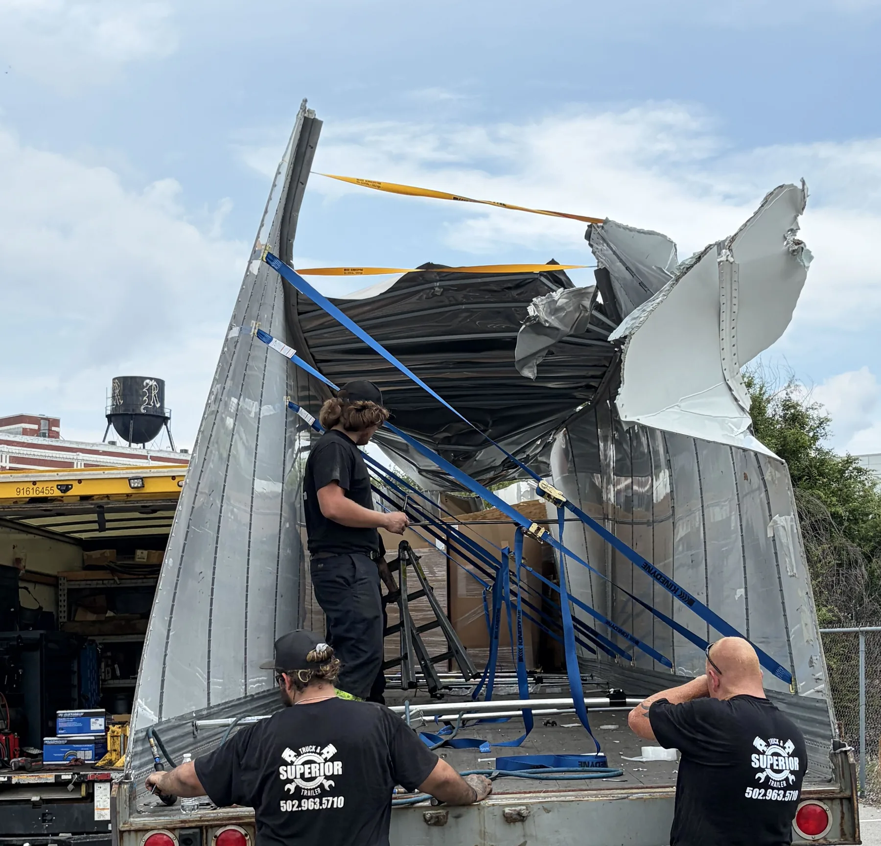 The Superior crew working on a trailer with its roof torn open